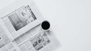黑色咖啡杯旁邊有白色表面上的新聞頭條。 — Old Paper 壁紙