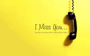 一個黑色轉盤電話聽筒掛在黃色牆上，帶有 I Miss You... 的訊息。 — 我想你 壁紙
