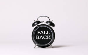 白色背景上帶有「FALL BACK」字樣的黑色鬧鐘。 — 時鐘 壁紙