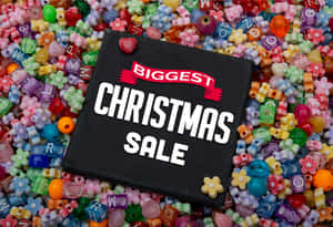 黑色標牌，寫有「Biggest Christmas Sale」，周圍環繞著色彩繽紛的字母和花朵珠子。 — Surface Pro 壁紙