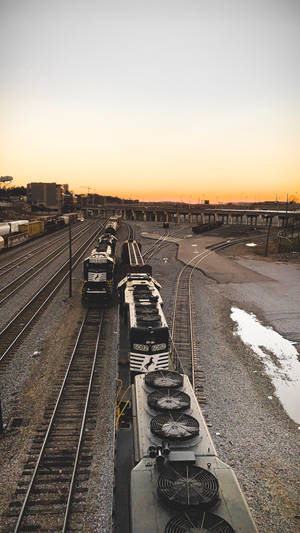 夕陽下的調車場貨運列車，橙色天空和碎石軌道 — 火車 壁紙