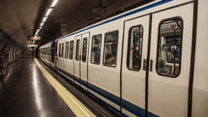 地下車站月台上的地鐵列車，地板反光，頭頂有燈光 — 地鐵 壁紙