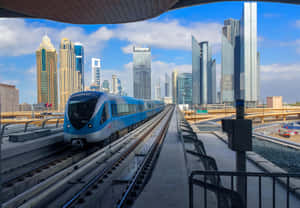 藍色地鐵列車在高架軌道上，背景有現代摩天大樓。 — 地鐵 壁紙
