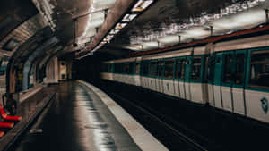 光線昏暗的地下車站月台上的地鐵列車，地板潮濕，天花板呈拱形。 — 地鐵 壁紙