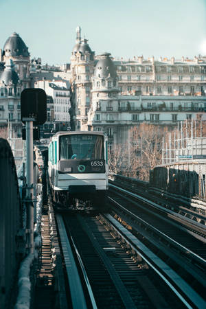 白色巴黎地鐵列車在高架軌道上，背景有歷史建築。 — 火車 壁紙