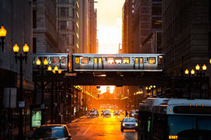 夕陽下的城市街道，高架軌道上有火車，下方有汽車。 — 火車 壁紙