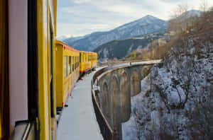 黃色火車穿越山谷中的雪石橋 — 火車 壁紙