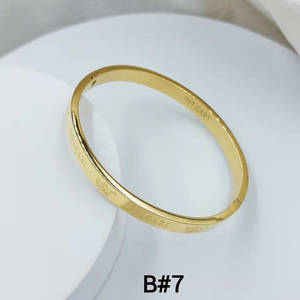 白色陶瓷碟上的一只黃金Bulgari手鐲。 — 金色動態 壁紙