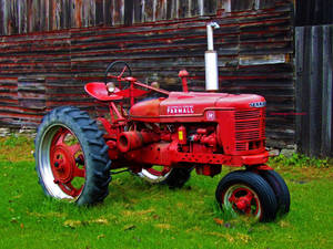 紅色復古 Farmall 拖拉機停在穀倉附近的草地上 — 復古 壁紙