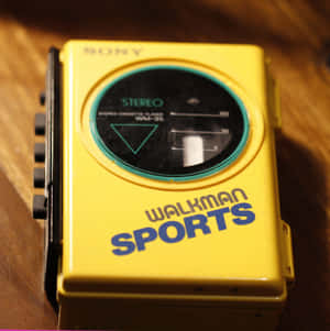 黃色復古Sony Walkman Sports卡式錄音機在木頭上。 — 80年代美學 壁紙