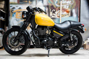 黃黑色 Royal Enfield 摩托車停放在佈滿塗鴉的車庫內。 — 旁遮普國王 壁紙