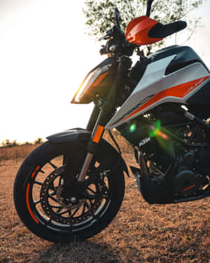 KTM Duke摩托車在日落時停放在草地上，帶鏡頭眩光 — 日落 壁紙