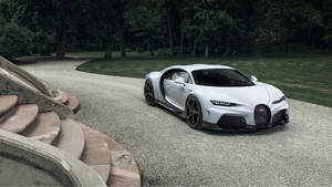 白色Bugatti Chiron停放在碎石車道上，有石階和綠樹。 — 白色法拉利 壁紙