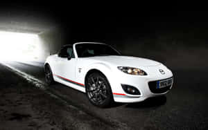 白色Mazda MX-5敞篷跑車駛出黑暗隧道進入明亮光線。 — 馬自達 壁紙