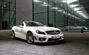 白色豪華跑車在夜晚停放在玻璃建築前。 — Mercedes Benz C300 壁紙