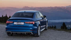 藍色 Audi RS3 轎車停泊在日落時分的山景觀景點。 — 凱迪拉克 壁紙