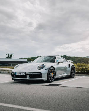 銀色保時捷911 Turbo S停放在停車場，背景有山丘。 — 保時捷 911 壁紙