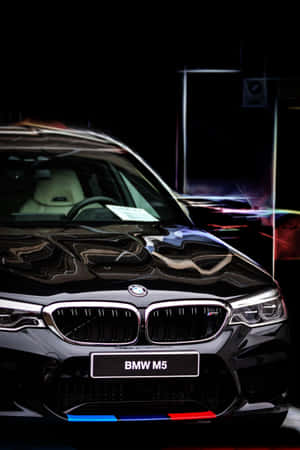 黑色BMW M5跑車，霓虹燈光在其光澤表面反射。 — 小米平板 8 壁紙