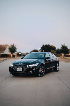 黑色Genesis G70轎車停泊在住宅街道上，黃昏時分。 — 黃昏 壁紙