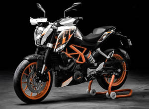 深色攝影棚中支架上的黑色和橙色KTM Duke摩托車。 — 巴布風機車 壁紙