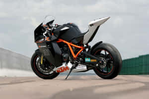 陰天中賽道上的黑色與橙色KTM RC8R運動摩托車。 — 登山車 壁紙