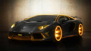 黑色藍寶堅尼 Aventador，在工作室環境中帶有發光的金色輪圈和飾邊。 — Studio Display 壁紙