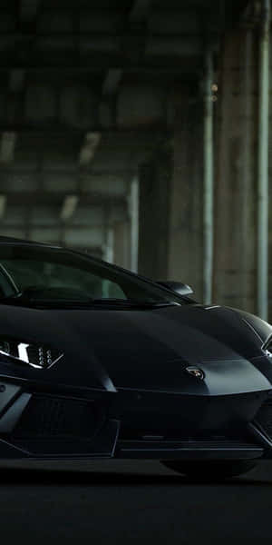 黑色藍寶堅尼Aventador在昏暗的工業車庫中，灰塵飄浮。 — 18:9 壁紙
