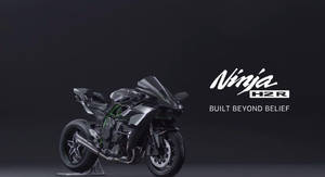 黑色 Kawasaki Ninja H2R 運動摩托車，帶有綠色點綴，置於深色背景上。 — 機車 壁紙
