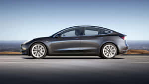 灰色Tesla Model 3在高速公路上行駛，背景有山丘。 — 特斯拉 壁紙