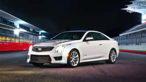 白色Cadillac ATS-V跑車在夜間亮燈的賽車場上。 — 凱迪拉克 壁紙