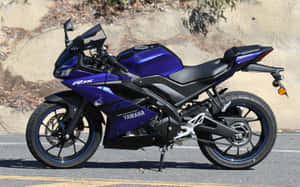 藍色Yamaha R15機車停在柏油路上。 — 16:10 壁紙