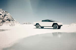 未來感白色卡車停在結冰的湖上，附近有積雪岩石。 — 特斯拉 壁紙