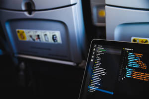 筆記型電腦在飛機托盤桌上顯示程式碼