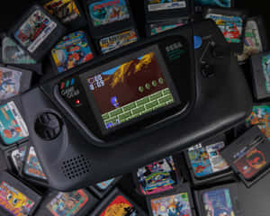 黑色Sega Game Gear主機正在玩Sonic遊戲，周圍環繞著遊戲卡帶。 — 酷炫遊戲 壁紙