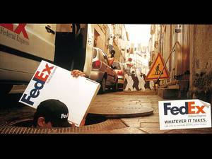 FedEx送貨工人在狹窄的城市小巷中從人孔中冒出。 — 聯邦快遞 壁紙