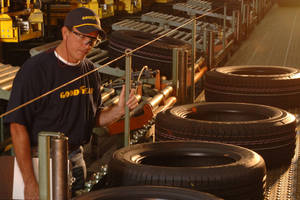 Goodyear工人在工廠輸送帶上檢查輪胎。 — 品牌 壁紙