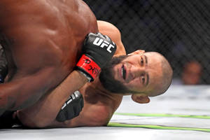 UFC拳手在八角籠內遭受地面打擊時痛苦的表情。 — 終極格鬥冠軍賽 壁紙