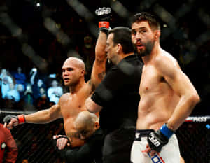 UFC拳手贏得比賽，裁判在八角籠中舉起他的手。 — 運動風 壁紙