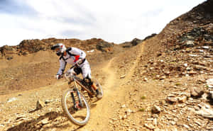 山地車手在乾燥景觀中沿著岩石土路飛馳而下 — 登山車 壁紙