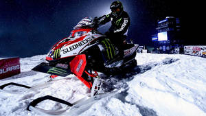 雪地摩托車賽車手在體育場燈光下於夜間雪道行駛。 — X Games 壁紙