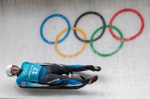 喬治亞雪橇運動員在可見奧運五環的冰道上飛馳。 — 極限運動 壁紙