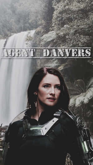 特工丹弗斯身穿戰術裝備站在森林中的瀑布前。 — 海蒂克隆 壁紙