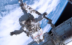 太空人在太空漫步時漂浮在太空中，背景是地球。 — 在我們之中 太空 壁紙