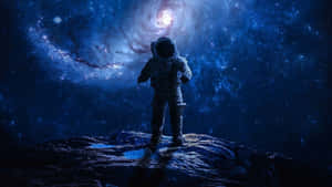 一名孤獨的太空人在岩石行星上欣賞發光的螺旋星系。 — 全高清 壁紙