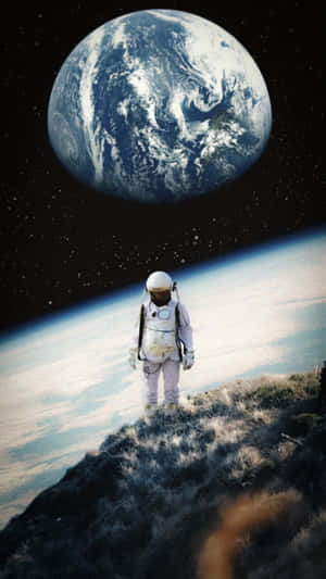 一名孤獨的太空人在山頂上從太空俯瞰地球。 — 獨自一人 壁紙
