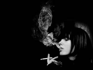女性在黑白照片中呼出骷髏形狀的煙霧。 — 煙動圖 壁紙