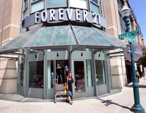 女性在陽光明媚的街角走出Forever 21商店，有路牌。
