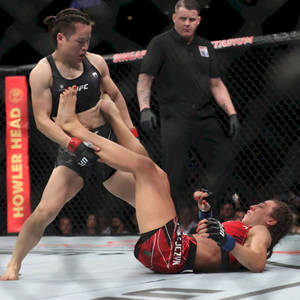 兩名女子MMA拳手在UFC八角籠內與裁判一起行動。 — 運動 壁紙