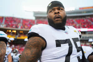 NFL球員在體育場穿著75號球衣，手臂上有刺青。 — 酷炫足球 壁紙