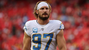 NFL球員身穿白色球衣號碼97，帶有藍色和金色點綴，站在足球場上。 — 運動 壁紙
